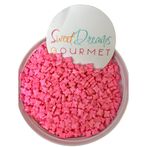 a bowl filled with pink sugar cubes next to a sign that says sweet dreams