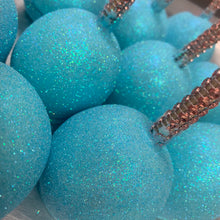 a bunch of blue balls with glitter on them