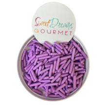 a bowl filled with purple crayons sitting on top of a white table