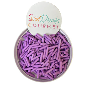 a bowl filled with purple crayons sitting on top of a white table