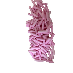 a pile of pink candles sitting on top of a white table