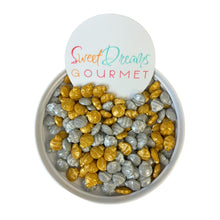 a bowl of gold and silver rocks with a sign saying sweet dreams gourmet