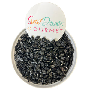 a bowl filled with black beads and a sign that says sweet dreams gourmet