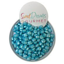 a bowl filled with blue candies next to a sign that says sweet dreams go