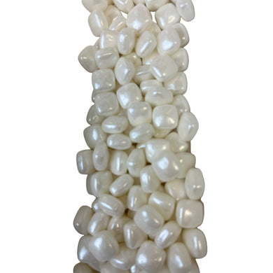 a large pile of white beads on a white background