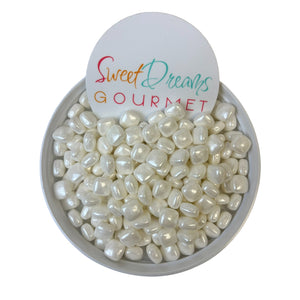 a bowl filled with white pearls and a sign that says sweet dreams gourmet