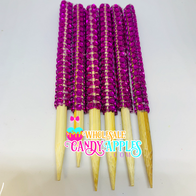 a group of wooden sticks with purple beads on them