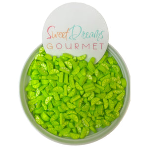 a bowl filled with green candies next to a sign that says sweet dreams go