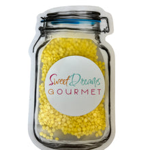 a jar filled with yellow candies on top of a white table