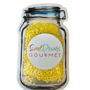 a jar filled with yellow candies on top of a white table