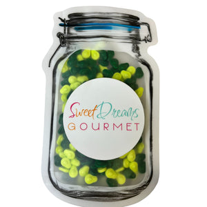 a jar filled with green and yellow gummy bears