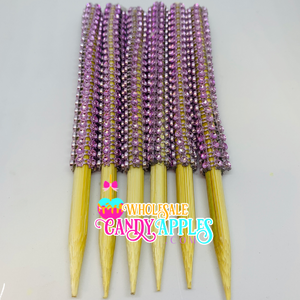 a group of purple and yellow toothpicks sitting on top of each other