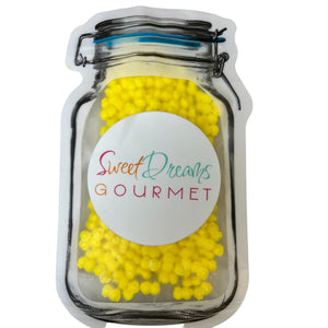 a jar filled with yellow candies on top of a white table