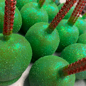 a close up of green apples with sparkle sticks sticking out of them