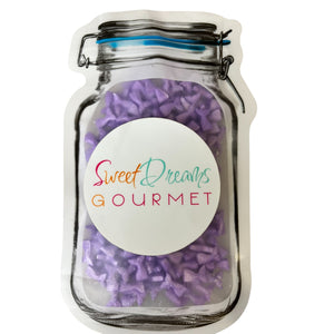 a jar filled with purple candies sitting on top of a table