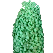 a large pile of green candies on a white background