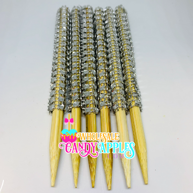 a group of yellow and silver metal straws on a white surface