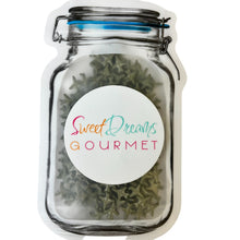 a jar filled with green sprouts sitting on top of a table