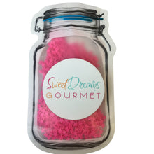 a jar filled with pink sprinkles on top of a white surface