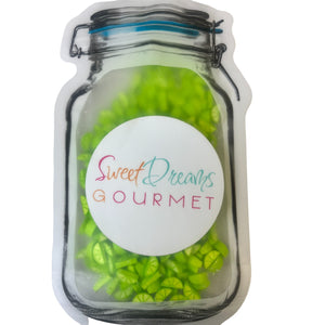 a jar filled with green gummy beans