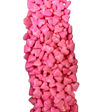 a bunch of pink heart shaped candies on a white background