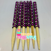 a group of purple and black beaded toothpicks