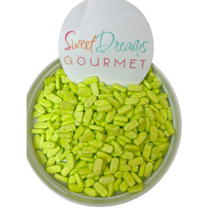 a bowl filled with green candies next to a sign that says sweet dreams go