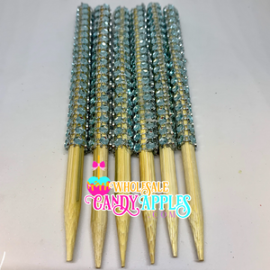 a bunch of gold and blue beads on a white surface
