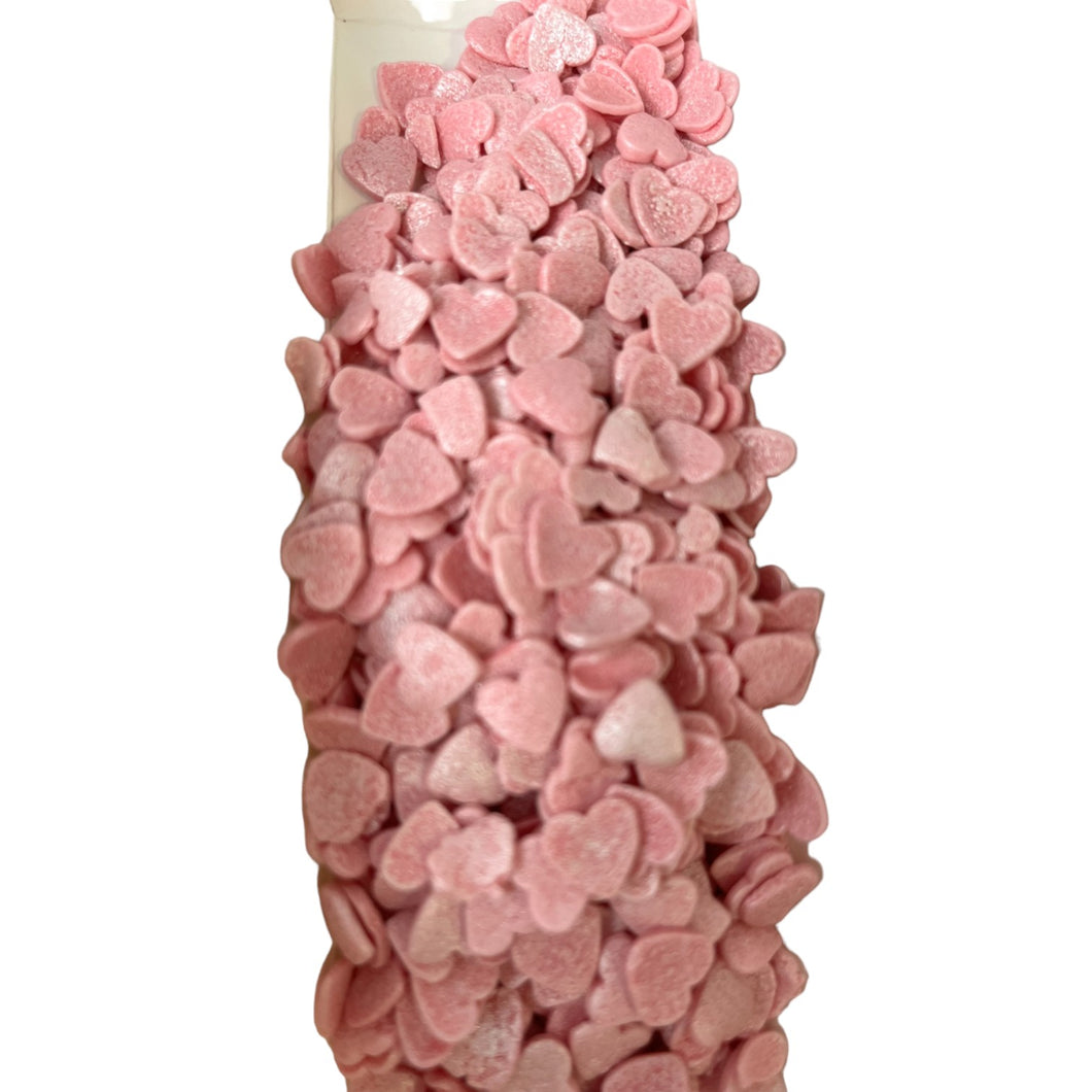 a bottle filled with pink and white candy hearts