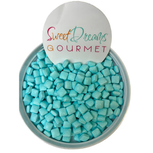 a bowl filled with blue candies and a sign that says sweet dreams gour