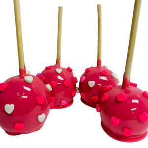 three red cake pops with hearts on them