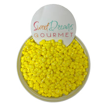 a bowl of yellow candy corn with a sign that says sweet dreams gourmet